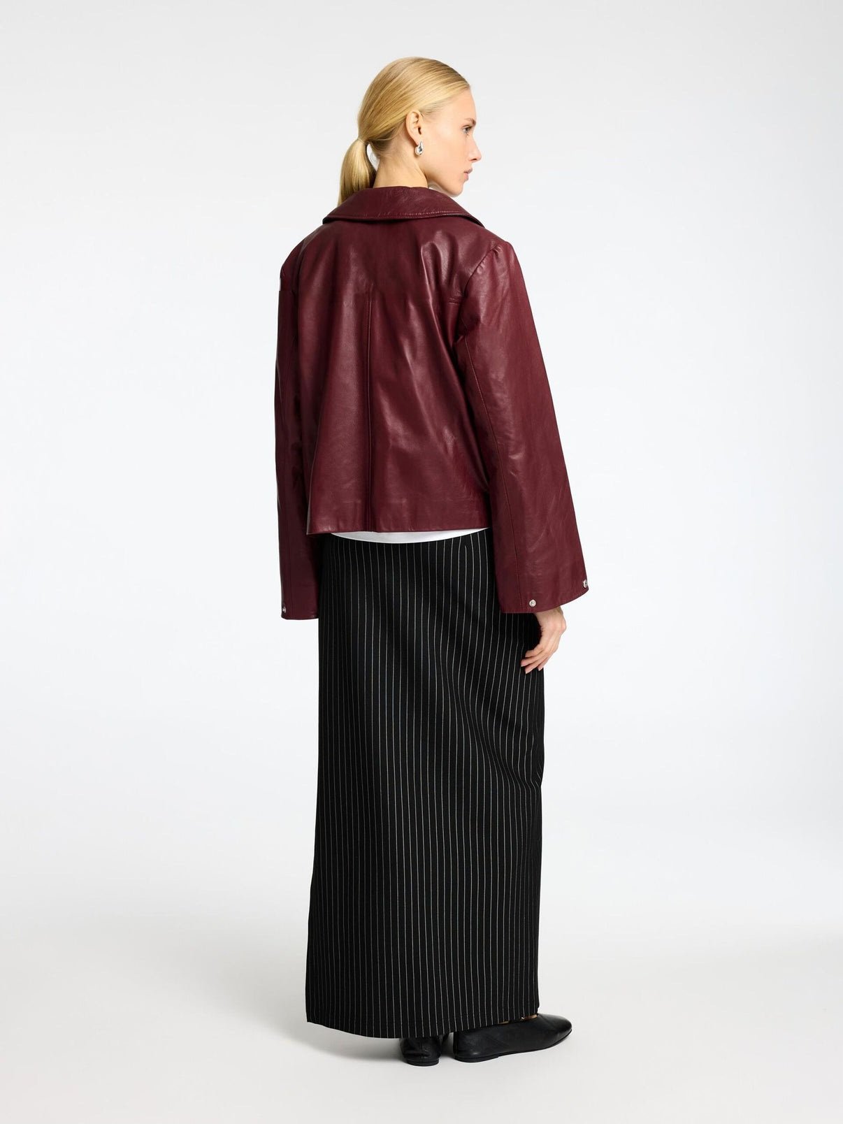Close up of the premium faux leather texture and structured drop-shoulder design on the burgundy boxy leather jacket