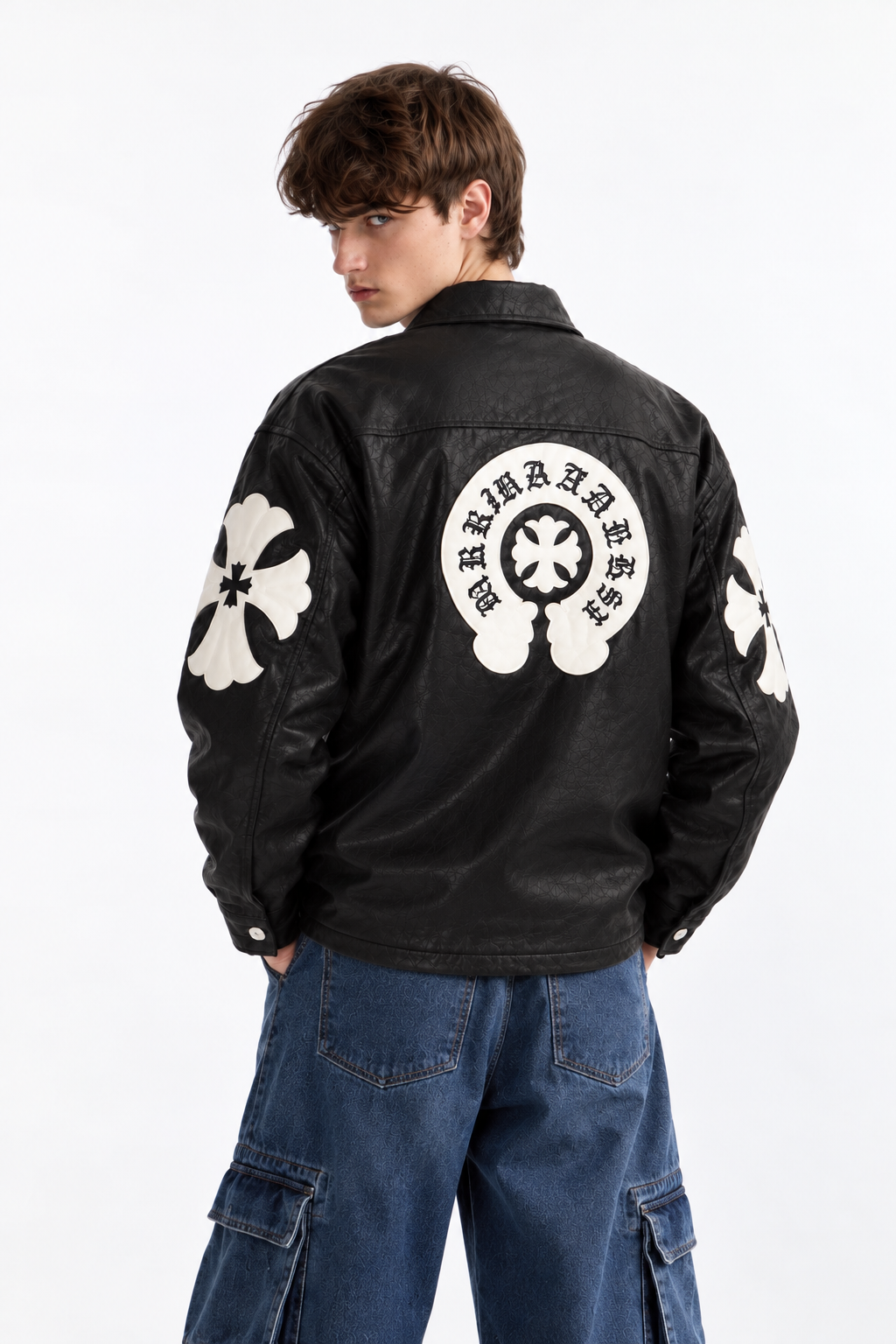 Back angle of male model wearing the black Gothic leather jacket, displaying the tonal black stitched cross patches across the back and sleeves
