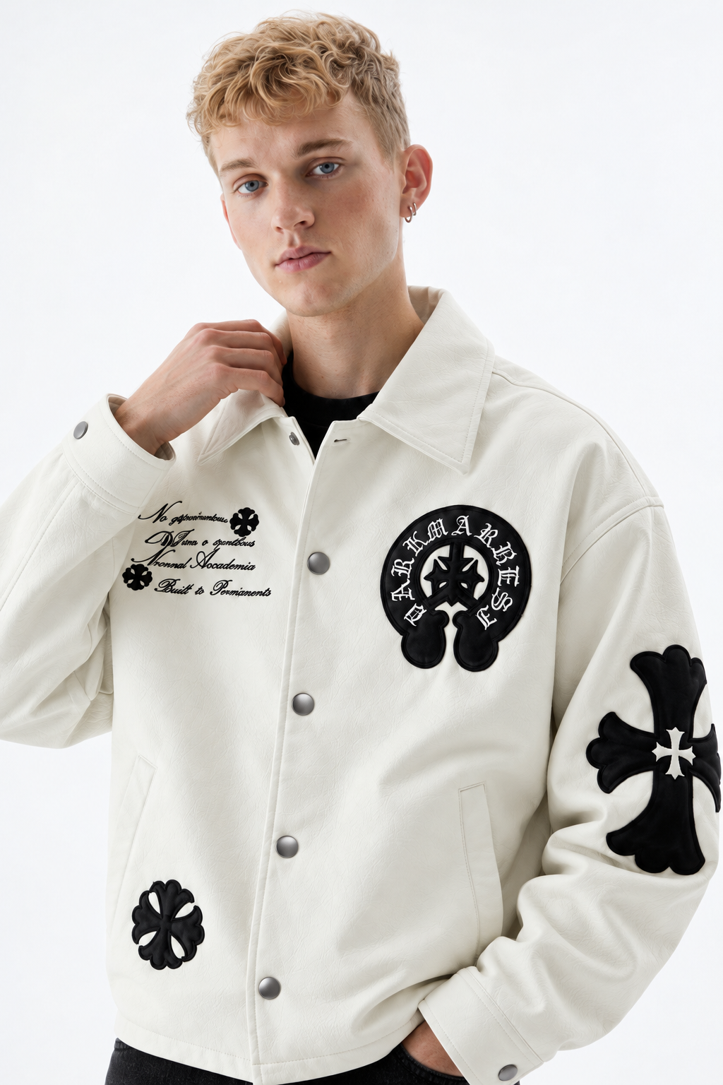 Front view of male model in the Exotix Chalk White Gothic cross patch faux leather jacket showing the boxy Y2K fit and spread collar