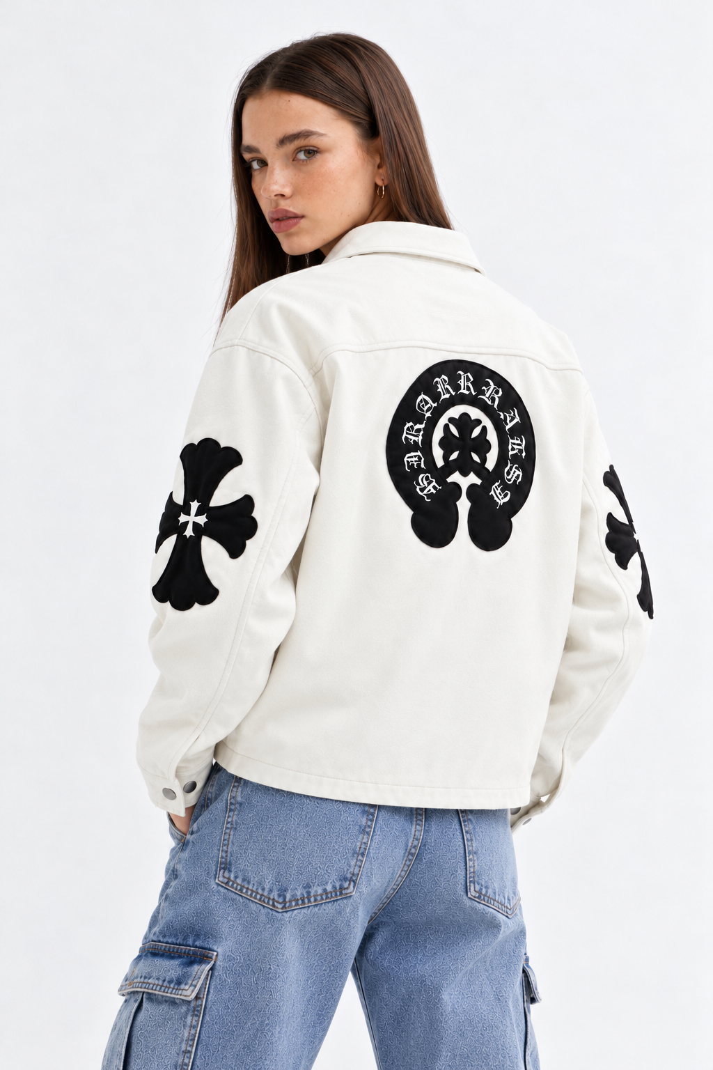 Rear view of female model showcasing the stitched black leather cross patches and large Gothic back emblem on the cream leather body