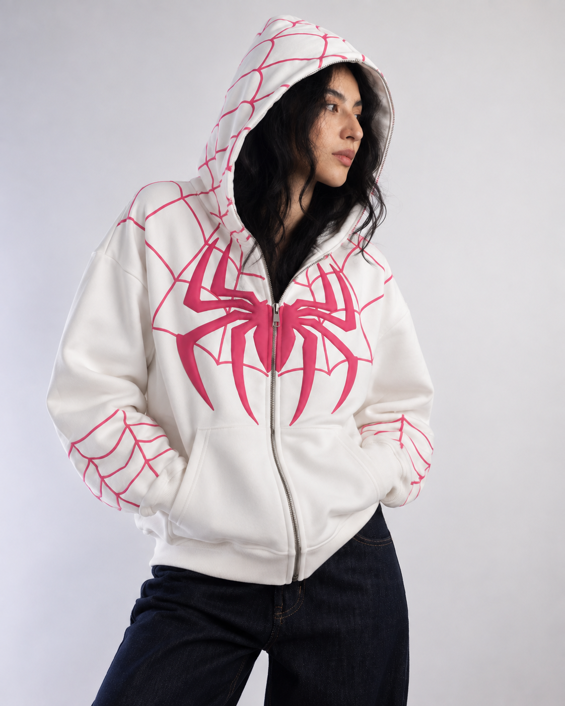 Front view of the girl wearing the Exotix white zip-up hoodie, focusing on the split kangaroo pocket and puff print web design