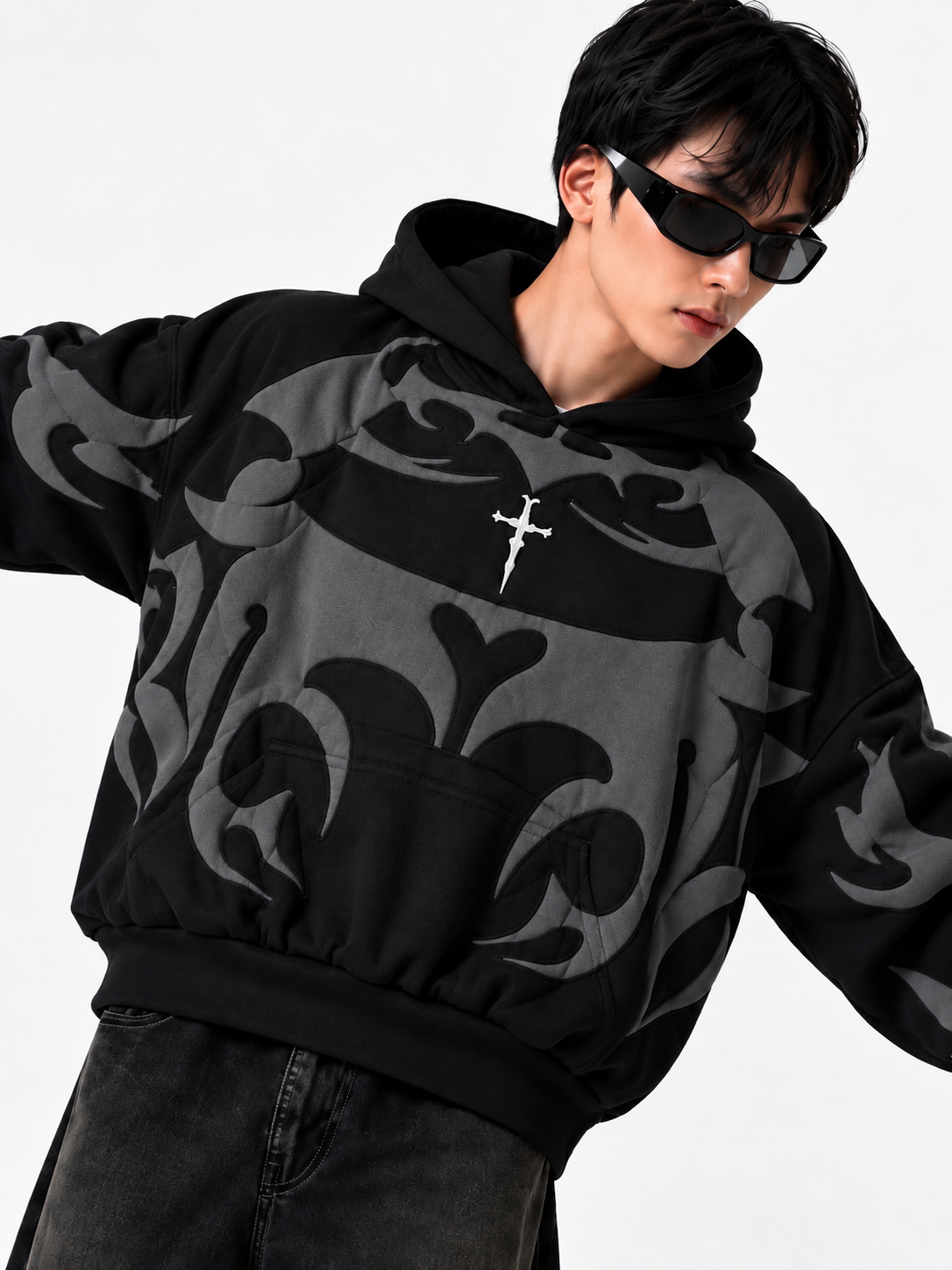 Close up of the boy in the black depth hoodie emphasizing the comfortable front kangaroo pouch and baggy fit