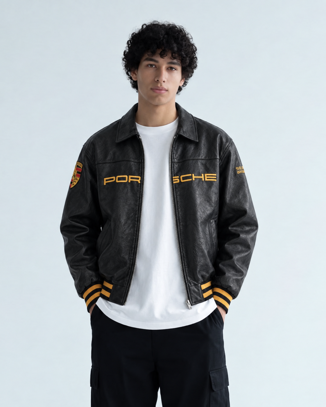 Front view of a boy wearing the Black Porsche Leather Jacket by Exotix, highlighting the regular fit and total embroidery