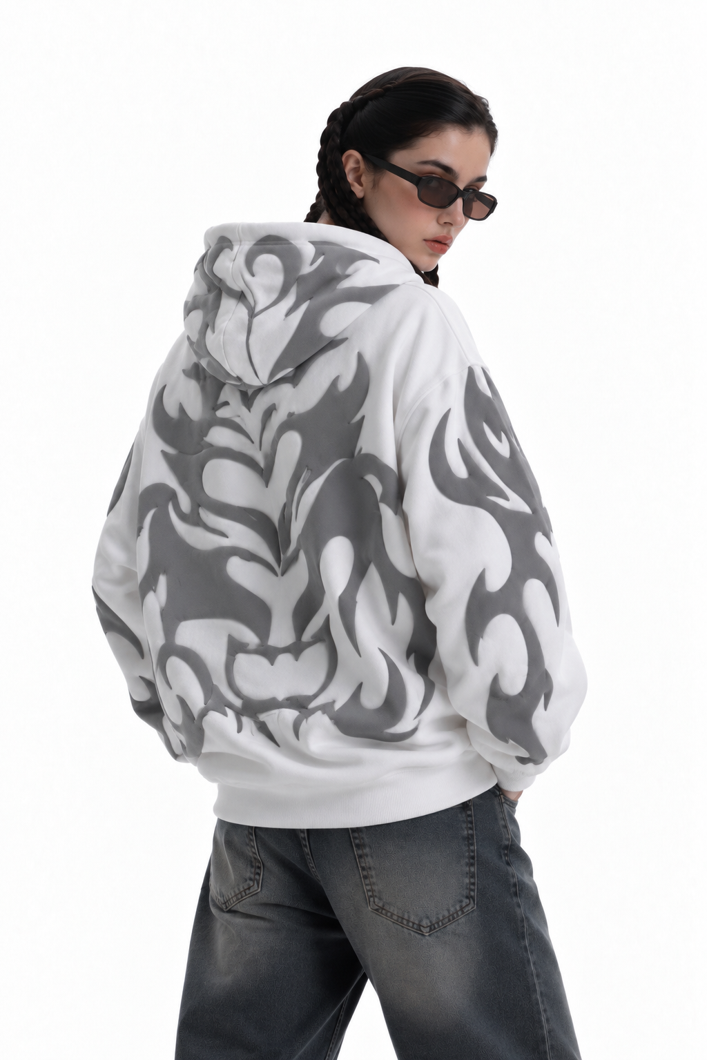 Back side shot of the white Exotix hoodie on a female model, focusing on the heavy 3D puff print tribal shadows