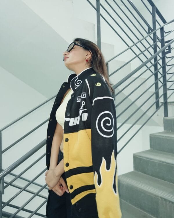 Side profile of Anushka Sen modeling the Exotix Naruto Flame Patch Jacket – yellow-black contrast