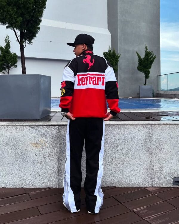 Man wearing Exotix Red & White Ferrari Racing Jacket, back view by rooftop pool