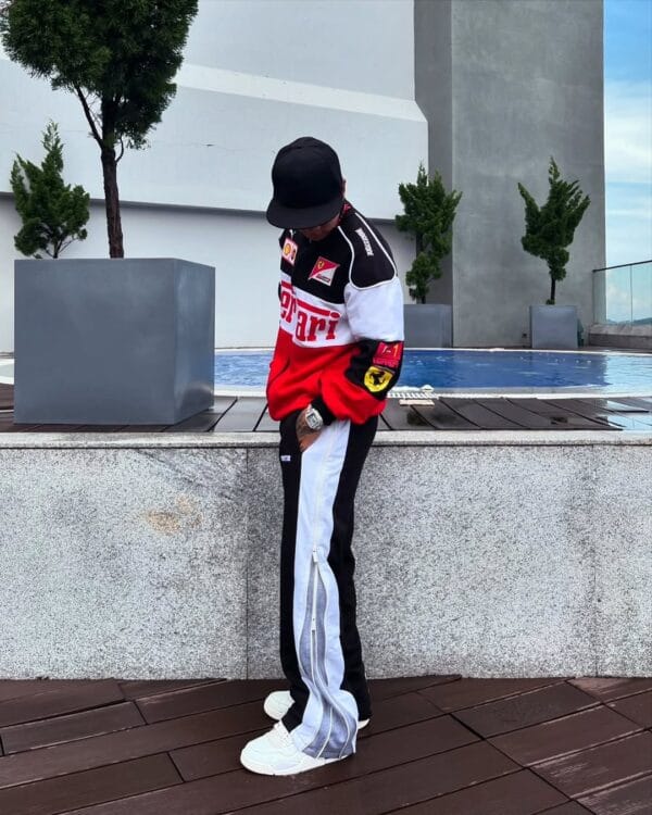 Side view of man in Red & White Ferrari Motorsport Jacket by Exotix near rooftop pool
