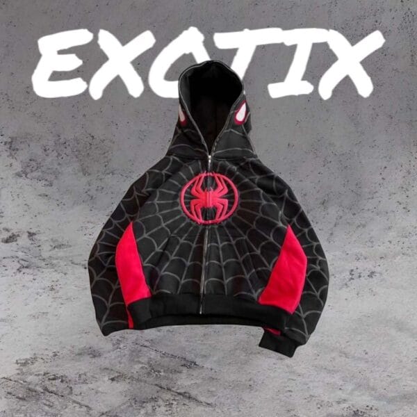 A red and black Spiderman-style hoodie laid flat on a concrete background, showing spider web patterns and a black spider emblem, with “EXOTIX” written in bold white letters above.