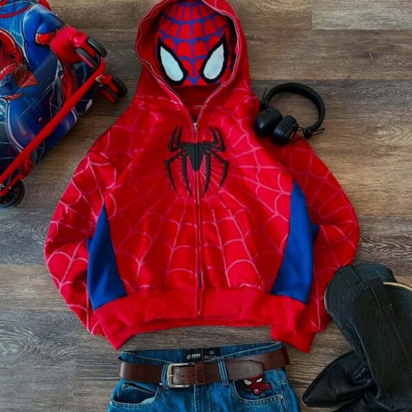 A person wearing a red and blue Spiderman-inspired hoodie with web patterns, taking a mirror selfie in an elevator with the hood covering their head.