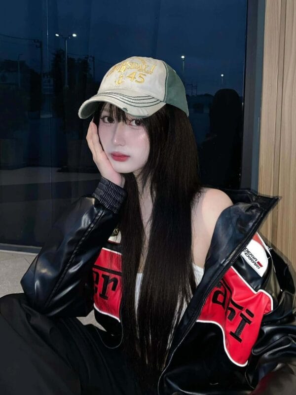 Girl in black Ferrari jacket and cap posing at night in racing streetwear – Exotix India