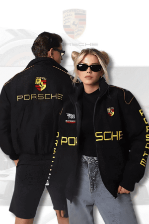 Man and woman wearing black Porsche F1 jackets by Exotix, featuring bold yellow racing logo on front and back.