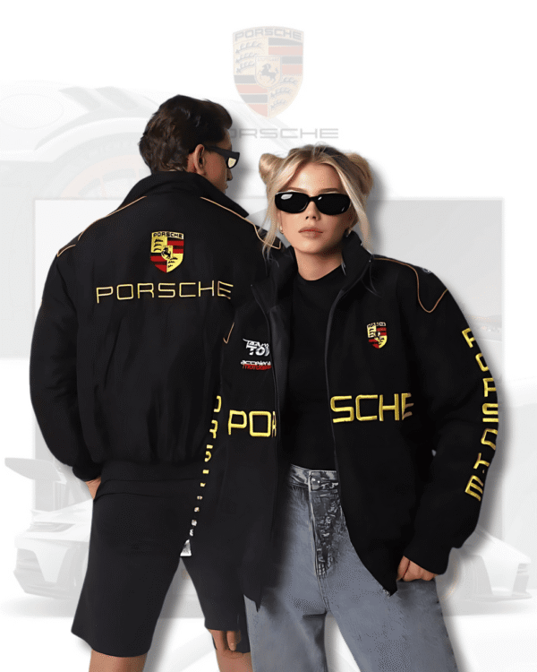 Man and woman wearing black Porsche F1 jackets by Exotix, featuring bold yellow racing logo on front and back.