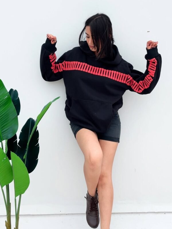 Model styling Exotix I Love You Thiiis Much Hoodie – oversized black hoodie with statement red printed design.