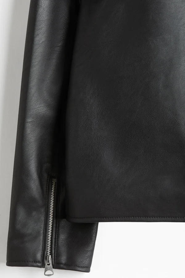 Black boxy leather jacket sleeve detail showing silver zipper closure and premium faux leather texture - Exotix