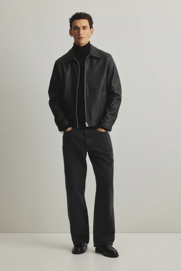 Man wearing black boxy leather jacket with cropped fit paired with turtleneck and jeans - Exotix streetwear style