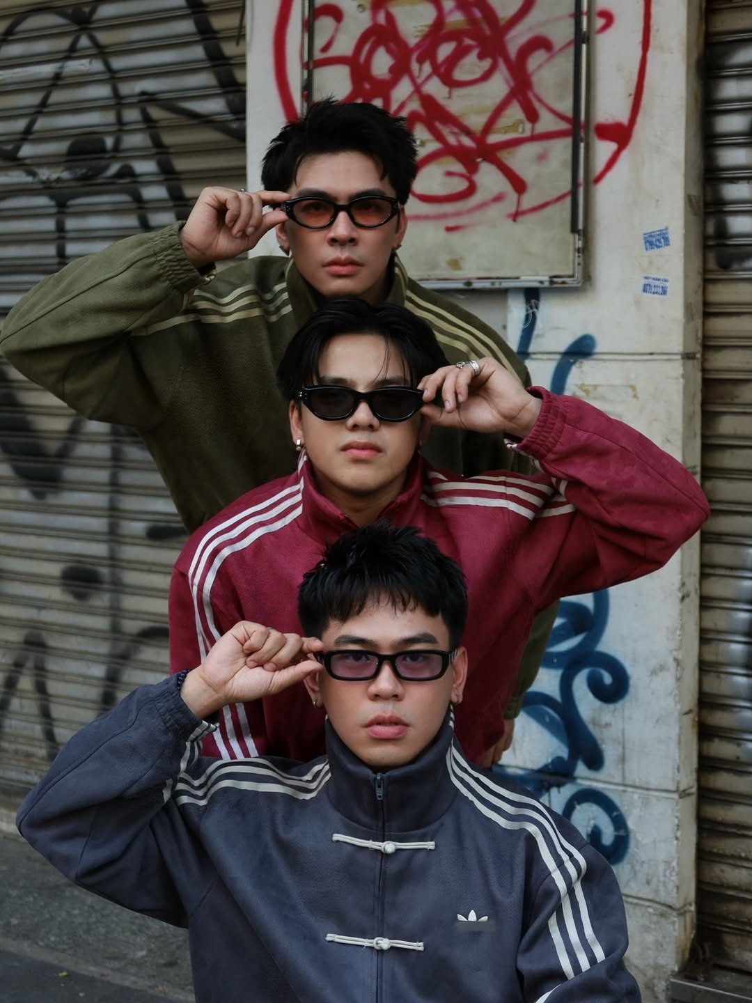 Chinese New Year Jacket – Exotix CNY Edition Street style portrait of three men wearing Chinese New Year Jacket from Exotix collection, layered in maroon, olive green, and dary grey with modern urban backdrop.