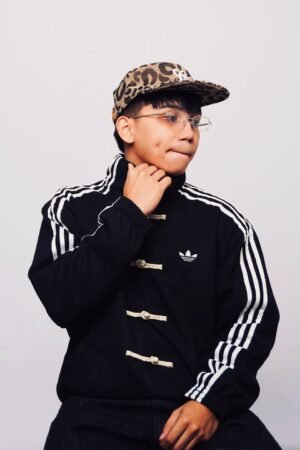 Black CNY jacket upper body close-up showing Mandarin collar and pankou frog button toggle detail — Exotix viral Tang jacket India streetwear